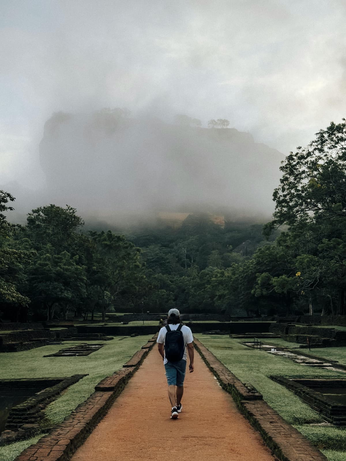 Sigiriya Rock hidden by low cloud, seen from the water gardens on a wet-season day