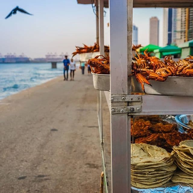 Seafront snack stall selling fried seafood beside the ocean promenade in Colombo