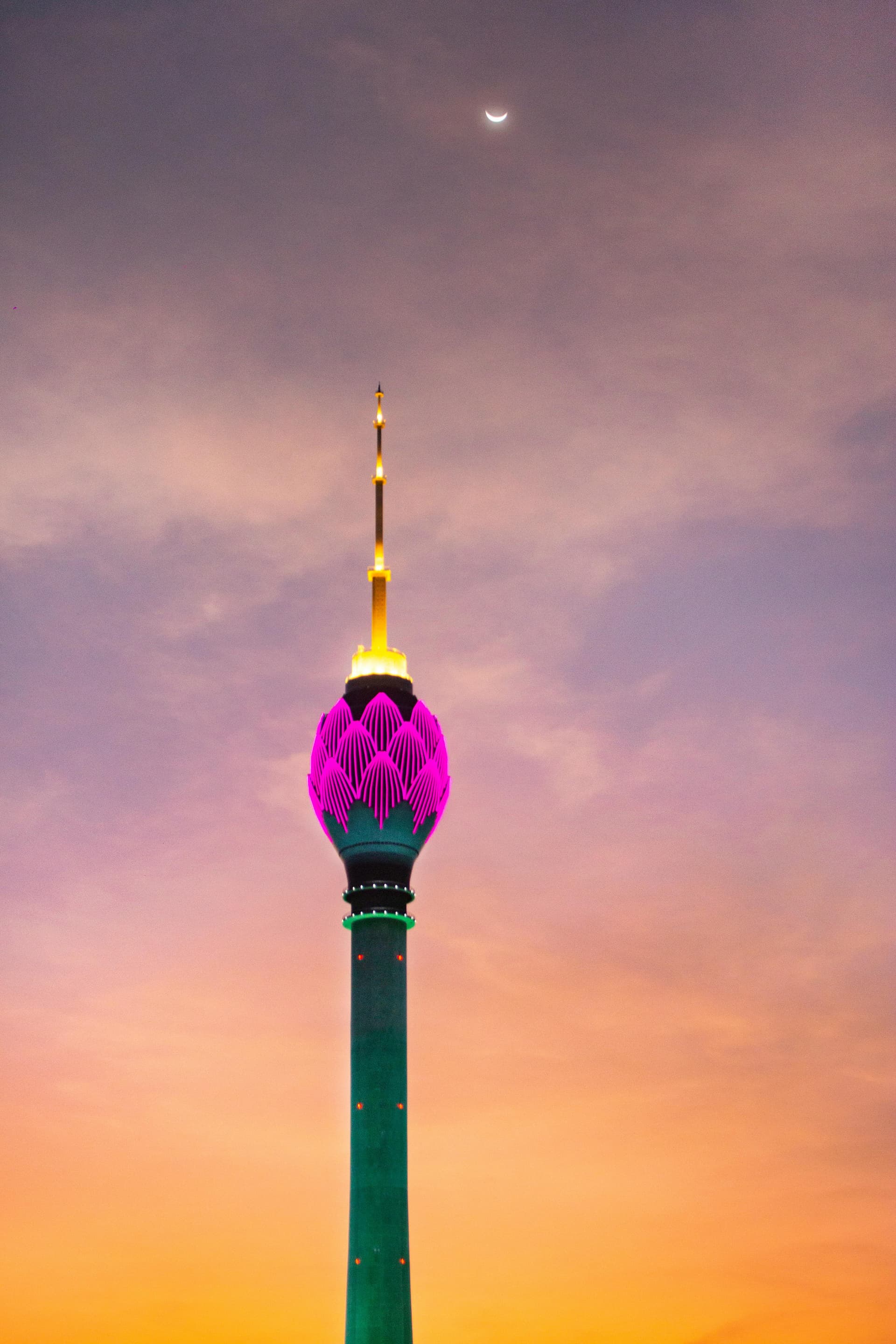 The Colombo Lotus Tower lit in pink and gold against the evening sky, Sri Lanka